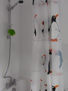 a shower curtain with penguins on it in a bathroom at Carters Guesthouse in Milton Keynes