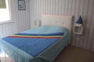 - une chambre avec un lit et une couverture colorée dans l'établissement VUE MER PREFAILLES, PLAGE à 50m, à Préfailles