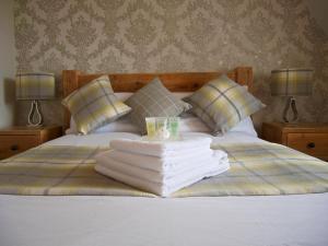 a bed with a pile of towels on it at 18 Craigmillar Park in Edinburgh