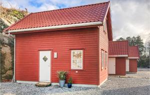 un cobertizo rojo con techo rojo y puerta blanca en Gorgeous Home In Lyngdal With Kitchen, en Lyngdal