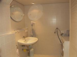 een witte badkamer met een wastafel en een spiegel bij Ferienwohnung Ströbele in Badenweiler