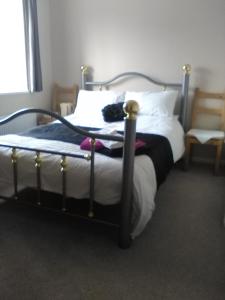 a bedroom with a bed with white sheets and pillows at Carters Guesthouse in Milton Keynes