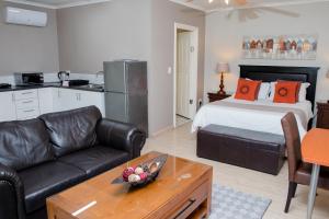 a living room with a bed and a couch at 85 Ehmke Guesthouse in Nelspruit