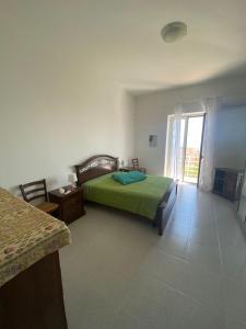 a bedroom with a green bed and a window at Albahome, Comoda casa vacanze centralissima e panoramica in Agrigento