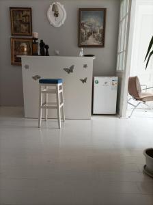 a kitchen with a counter and a stool and a refrigerator at Citalna Rooms in Bitola