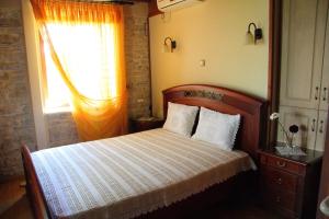 a bedroom with a wooden bed and a window at Villa Votsalo in Kiónion