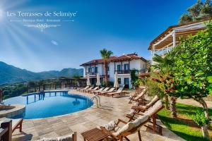 a villa with a swimming pool and a resort at Les Terrasses De Selimiye in Selimiye