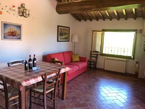 a living room with a red couch and a table at Il Gufo del Chianti in Montespertoli