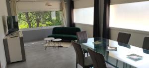 a living room with a table and a green chair at Maison Pré Long et Pré Long House in Le Thoronet