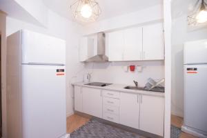 a kitchen with white cabinets and a white refrigerator at Travel & Live Marques in Porto