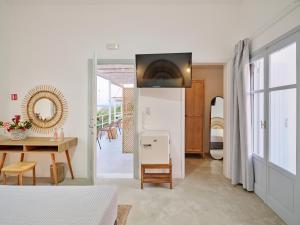 1 dormitorio con cama, mesa y comedor en Bonatsa Beach House, en Kimolos