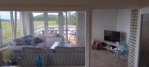 a living room with a couch and a television at Ostseeurlaub-Asmussen Nieby in Nieby