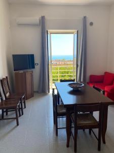 a living room with a table and a couch and a television at Albahome, Comoda casa vacanze centralissima e panoramica in Agrigento