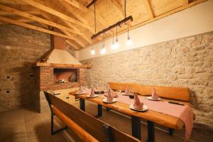 a dining room with a long table and benches at Apartman Berto in Vrsi