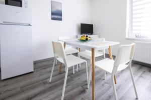 a white dining room table with white chairs and a computer at Penzion Na Obci Třeboň in Třeboň