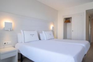 a large white bed with white pillows in a room at Helios Mallorca Hotel & Apartments in Can Pastilla