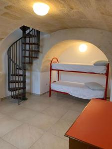 Habitación con litera y escalera en La Tortorella en Ginosa