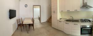 a kitchen with a table and a sink and a stove at La Tortorella in Ginosa