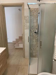 a shower with a glass door in a bathroom at La Tortorella in Ginosa