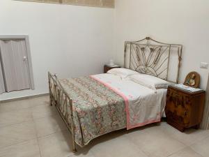 a bedroom with a bed and a wooden night stand at La Tortorella in Ginosa