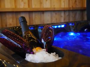 a bottle of wine in a sink with snow at Rest At Last - Highland Apartment with Private hot tub in Whitebridge