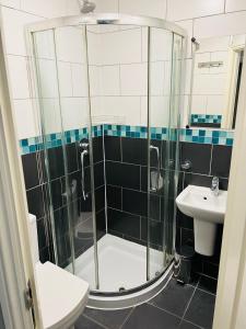un bagno con doccia, WC e lavandino di Comfotel BLU a Londra