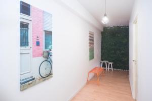 a hallway with a chair and a bike on the wall at Travel & Live Marques in Porto