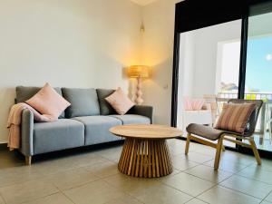 een woonkamer met een bank en een tafel bij Flamingo Mojácar in Mojácar