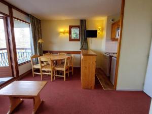 アーク 1801にあるAppartement 3 pièces 6 pers, Résidence calme proche télécabine, animaux admis, Arc 1800 - FR-1-411-34のテーブルと椅子のあるキッチンとダイニングルーム