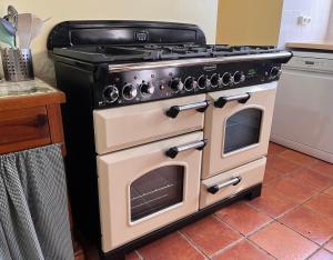 a black and white stove in a kitchen at La Maison du Passeur in Availles-Limouzine +15 photos