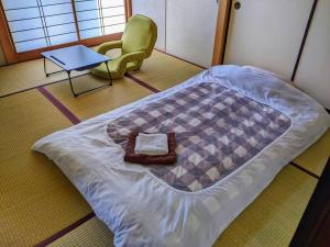 軽井沢町にあるOiwake House 1Bの椅子とテーブルが備わる客室のベッド1台分です。