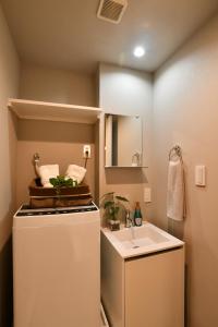 uma pequena casa de banho com um lavatório e um frigorífico em FL Residence Todai II em Tóquio