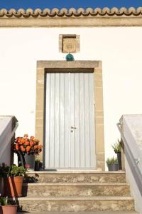 a white door on a building with stairs at Vranadika in Livadi