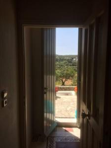 an open door with a view of a yard at Vranadika in Livadi +29 photos