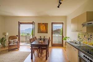 a kitchen with a table and a dining room at Waldvilla BERGSEE in Bodensdorf