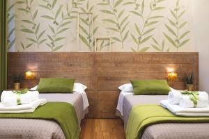 una camera con due letti di colore verde e bianco di Dimora Pertusa a Orvieto