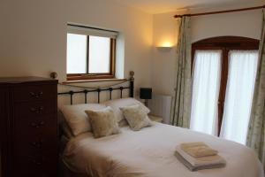 a bedroom with a large white bed with a window at Holly Lodge Country Guest House in Blidworth