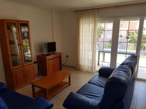 sala de estar con sofá azul y TV en residencial nerea, en Peñíscola