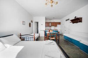 a room with two beds and a kitchen with a table at Διαμέρισμα στη Χώρα Σερίφου in Serifos Chora
