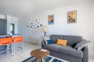 uma sala de estar com um sofá e uma mesa em Vue imprenable sur l'Ocean dans cet appartement pour six personnes em Pornichet