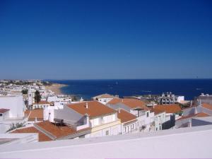 a view of a city with houses and the ocean at Casa Do Canto in Albufeira