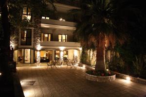 a palm tree in front of a building at night at Mousiko Pandoxeio in Steni Dirfyos