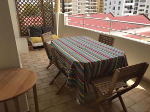 una mesa con un colorido mantel en el balcón en Lagos apartamento, en Lagos