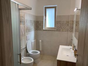 a bathroom with a toilet and a sink and a window at La Tortorella in Ginosa