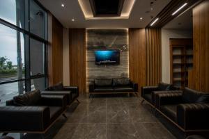 a waiting room with couches and a tv on a brick wall at GÜRSOY EXCLUSIVE HOTEL in Trabzon