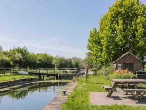 un parque con mesa de picnic y estanque en Wayside, Yorkshire Wolds Holiday Home en Nafferton