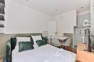 a bedroom with a bed and a table and a kitchen at indépendant flat: canal st martin&trains stations! in Paris