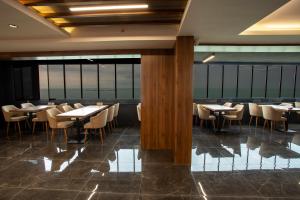 a dining room with tables and chairs and windows at GÜRSOY EXCLUSIVE HOTEL in Trabzon