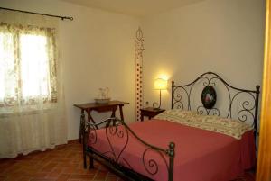 a bedroom with a red bed and a window at Il Gufo del Chianti in Montespertoli