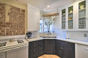 una cucina con mobili bianchi e un muro di mattoni di Warm and Welcoming Home Walk to Encanto Park! a Phoenix Altre 34 foto